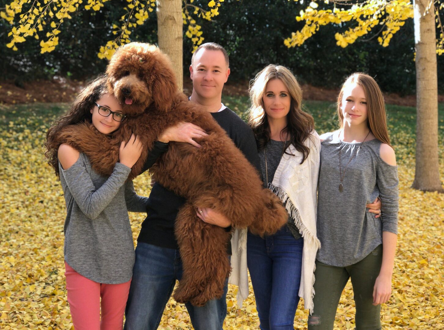 A family posing for a picture with their dog.