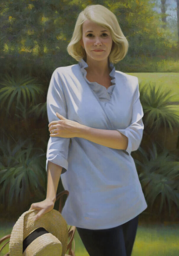 A woman standing in front of some bushes