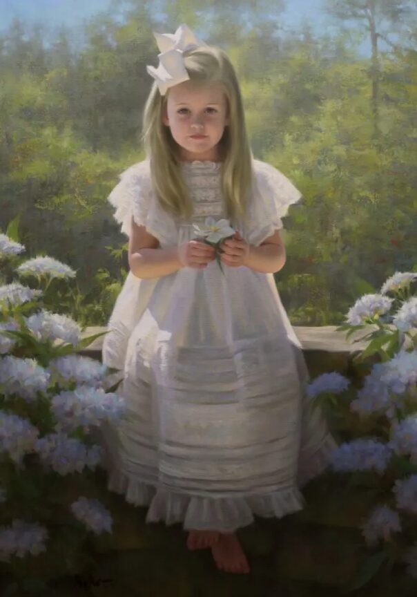 A little girl in white dress standing next to flowers.